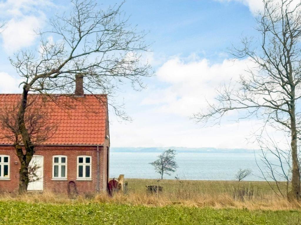 Una casa vieja con techo rojo en un campo en 8 person holiday home in Roslev, en Roslev