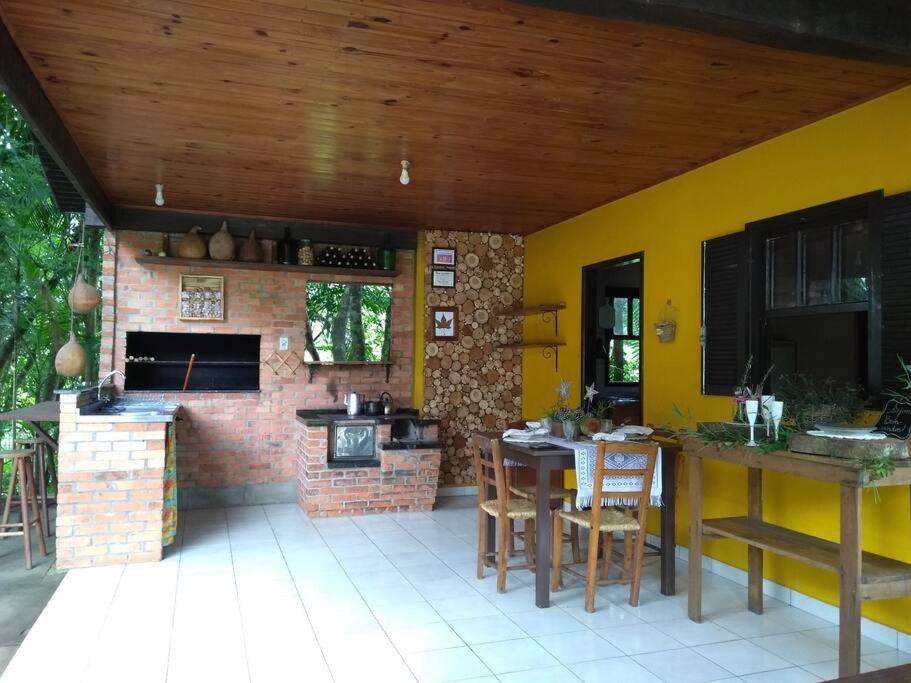 a kitchen with a brick oven and a table and chairs at Sítio em Nova Veneza - Caminho dos Pinheiros in Siderópolis