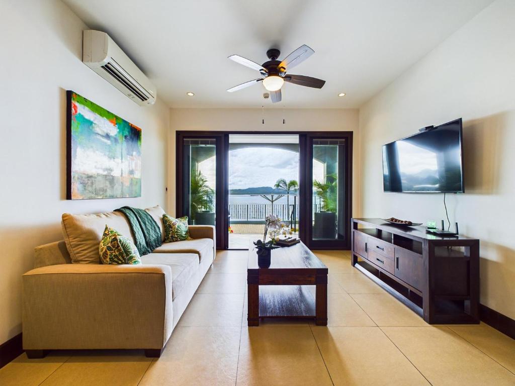 a living room with a couch and a flat screen tv at 360 Splendor 302-Ocean View Condo-Breakfast in Playa Flamingo