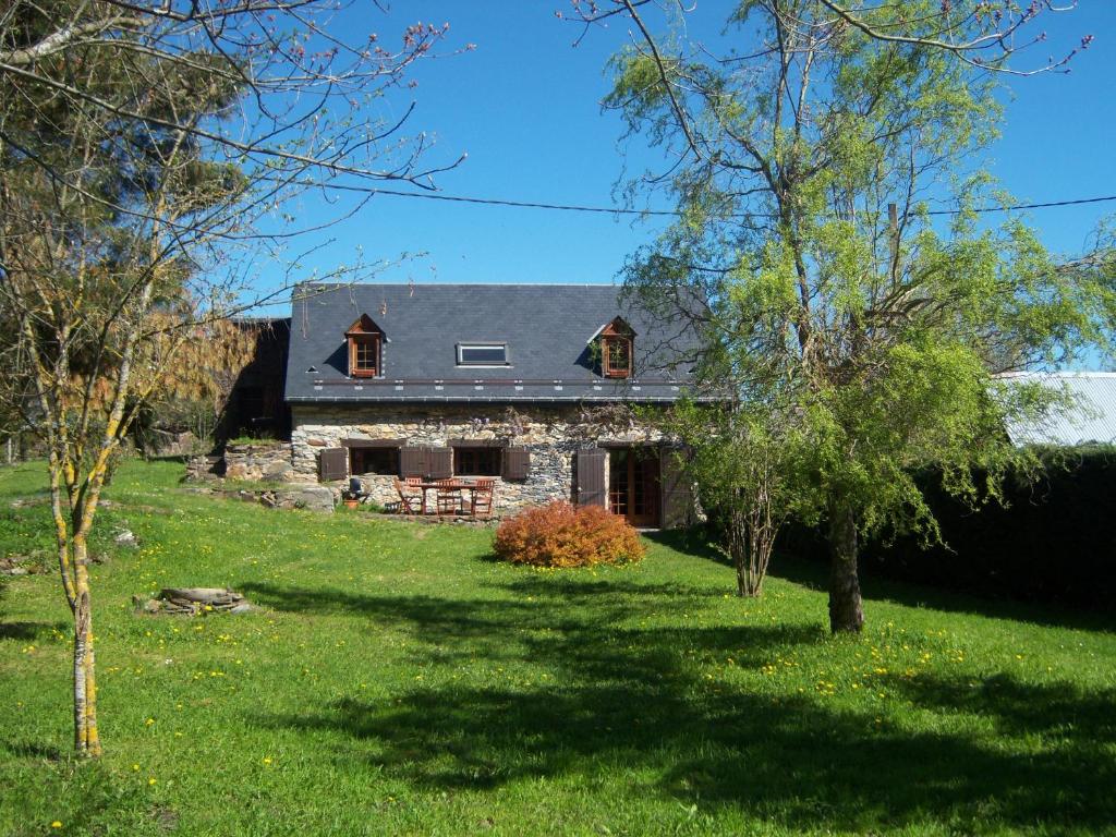 ein Steinhaus mit einem Gameradach in der Unterkunft La grange des Quatre saisons in Gouaux-de-Luchon
