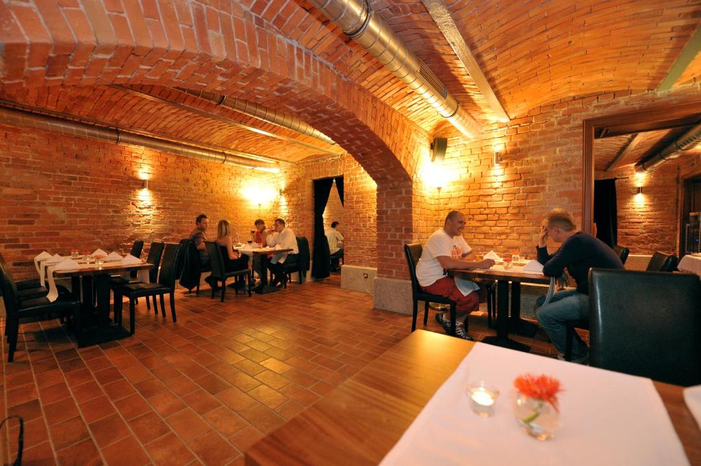 a group of people sitting at tables in a restaurant at Villa Vanilla in Kędzierzyn-Koźle