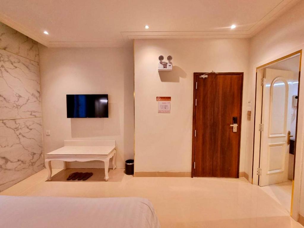 a room with a bed and a tv on a wall at Tulip Hotel 3 in Da Lat