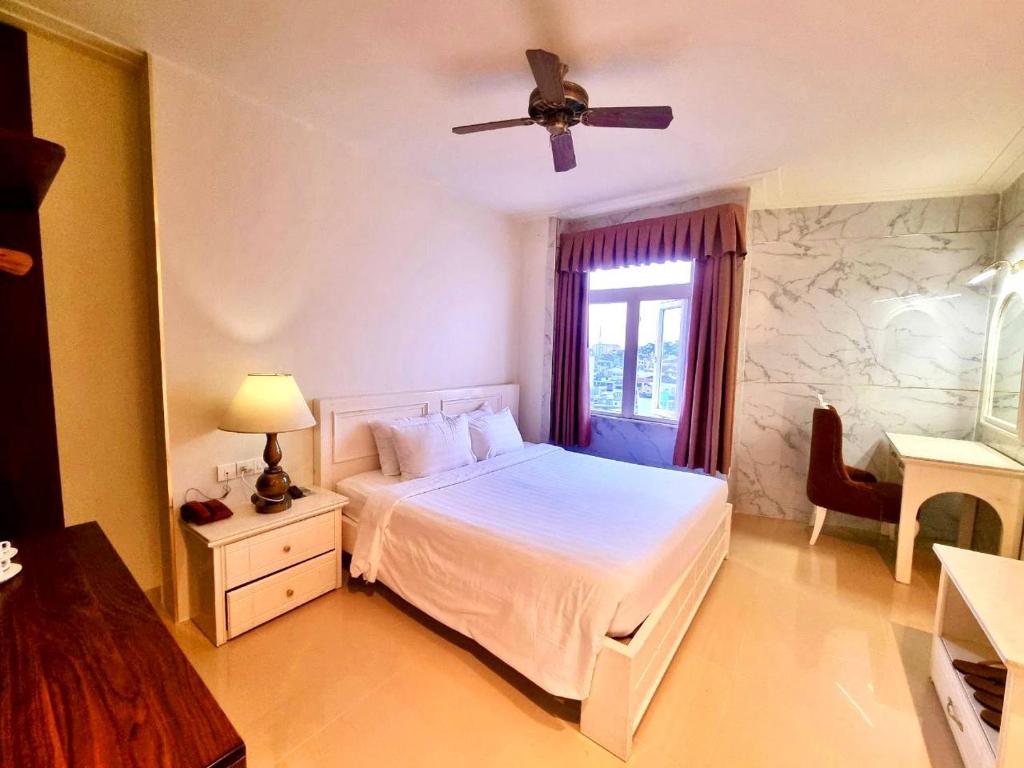 a bedroom with a bed and a ceiling fan at Tulip Hotel 3 in Da Lat