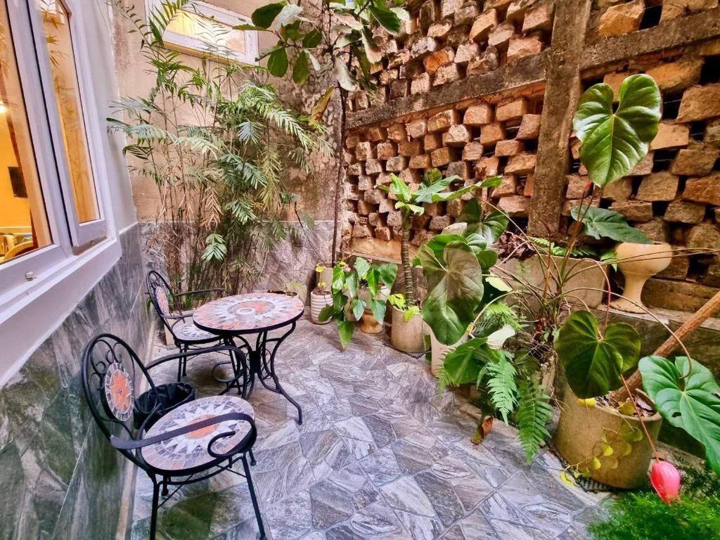 a patio with two tables and chairs and plants at Tulip Hotel 3 in Da Lat