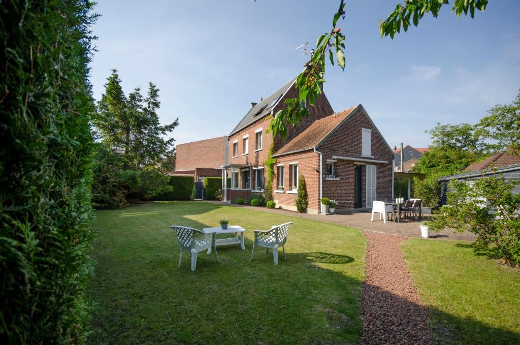 une maison avec une table et des chaises dans la cour dans l'établissement Gite Histoire de Maison, à Arras