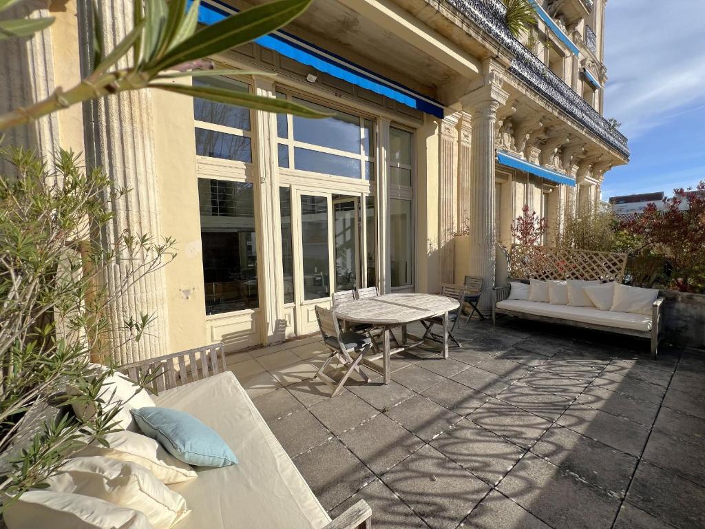 a patio with a table and a bench on a building at Appartement T4 Duplex Centre Arcachon, Terrasse Sud, Proche Plage et Commerces, Parking Inclus - FR-1-474-3 in Arcachon
