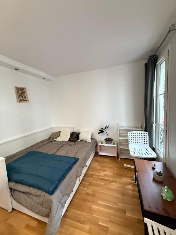 une chambre avec un grand lit et un parquet dans l'établissement 4Travellers Paris, à Paris
