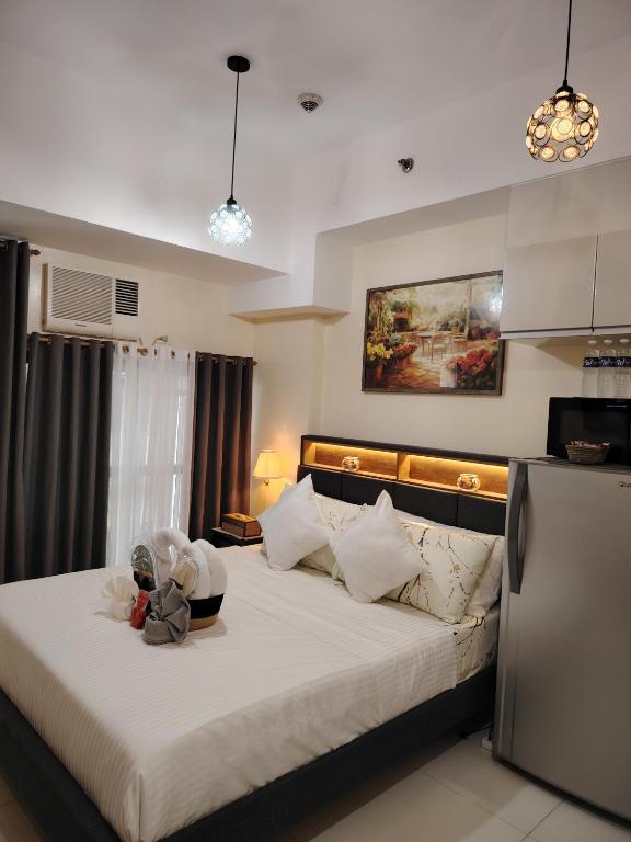 a bedroom with a large bed with a bowl on it at Stylish New Studio at McKinley Hill BGC Free Netflix in Manila