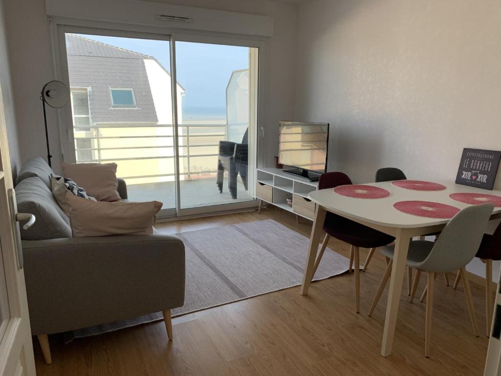un salon avec une table et un canapé dans l'établissement Appartement moderne proche plage pour 4 personnes - FR-1-482-152, à Fort-Mahon-Plage