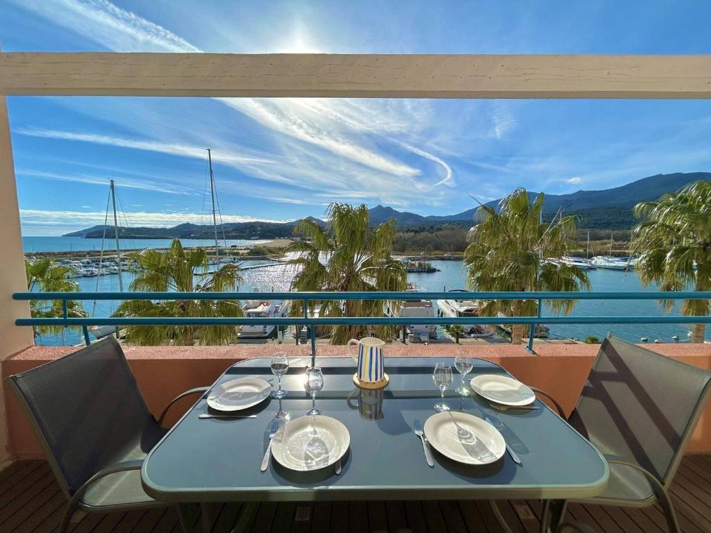 une table bleue avec des chaises et une vue sur l'eau dans l'établissement T2 Cabine Climatisé à Argelès avec Parking - FR-1-388-228, à Argelès-sur-Mer