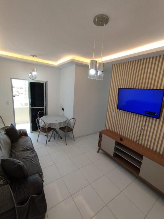 a living room with a couch and a flat screen tv at Apto Top Completo in Aracaju