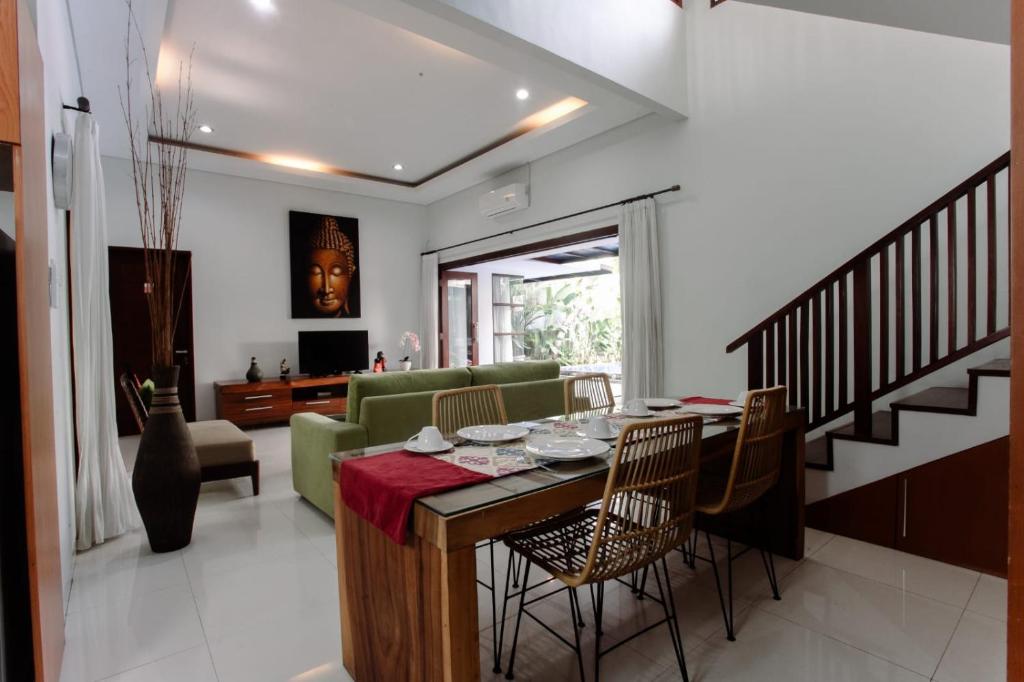 レギャンにあるBali mansion kutaのテーブルと椅子のあるダイニングルームとリビングルーム