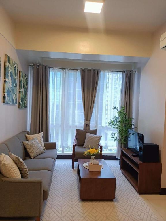 a living room with a couch and a tv at Mactan Newtown in Lapu Lapu City