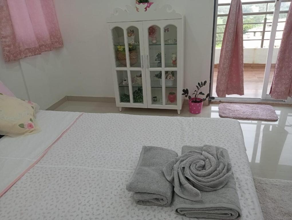 ナーシクにあるStay NC 2BHK apartmentのベッドルームにタオル付きのベッド1台