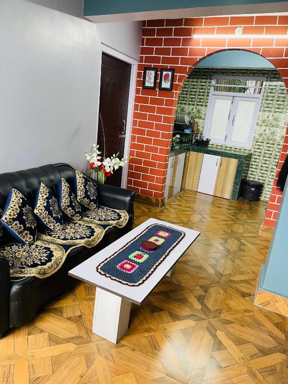 a living room with a couch and a table at Blue Valley Apartment in Darjeeling