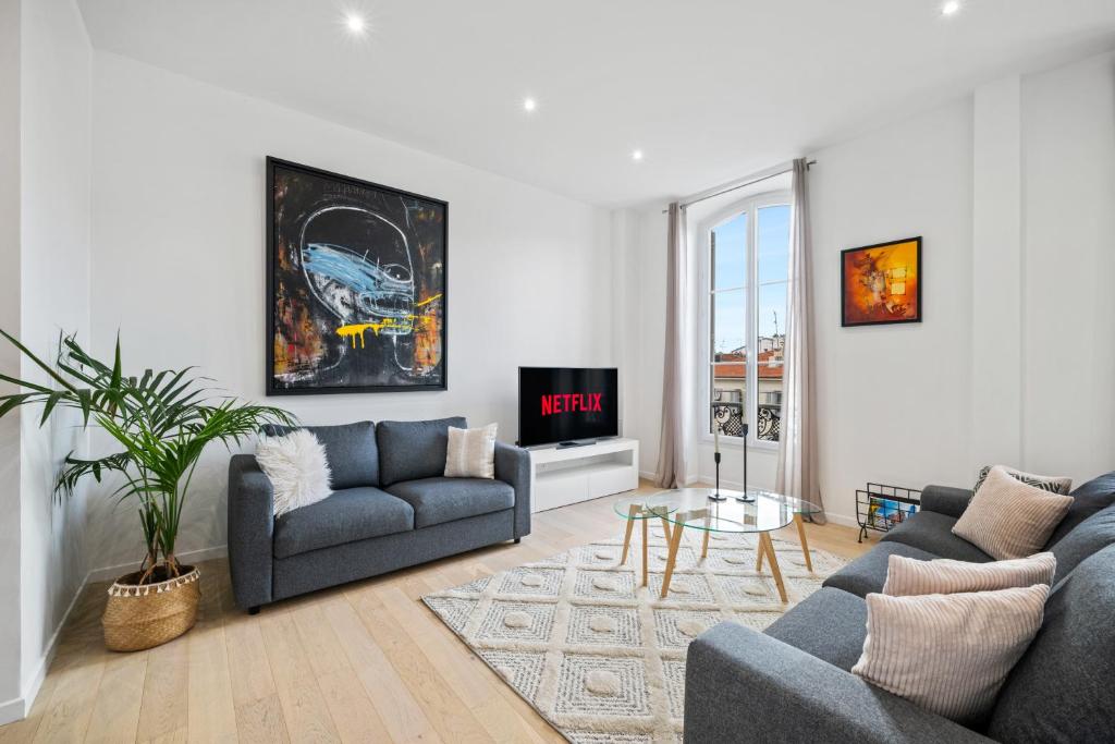 un salon avec deux canapés et une télévision dans l'établissement La Galerie 58 - Luxe & Design en centre ville, à Nice