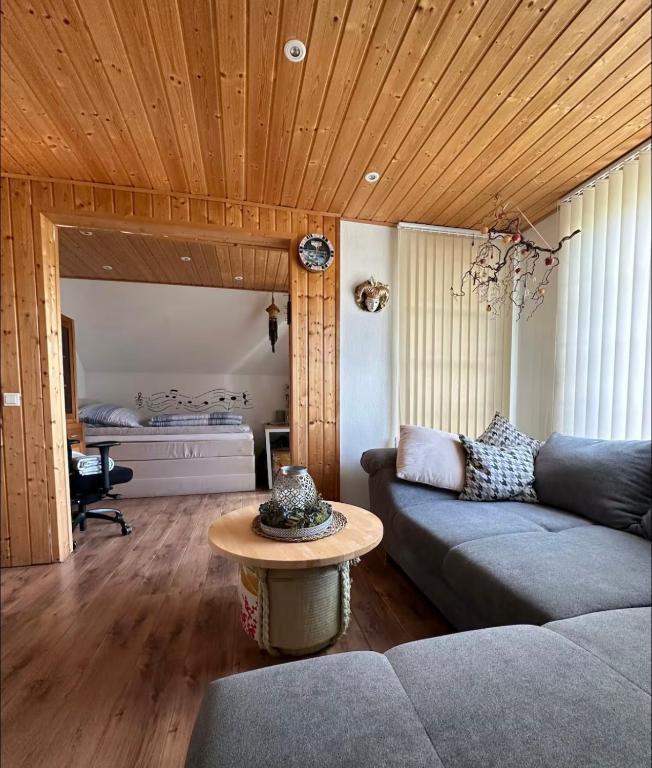 a living room with a couch and a table at Privatzimmer bei Renate am Grünen See in Ratingen