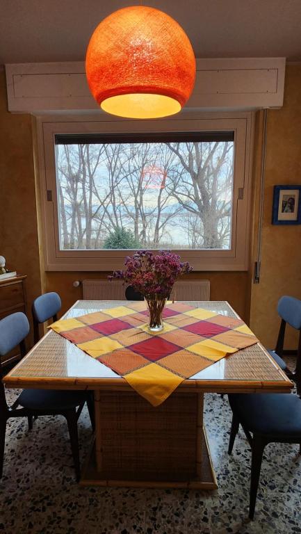 une table de salle à manger avec un vase de fleurs dessus dans l'établissement Lago a colazione pranzo e cena, à Dormelletto