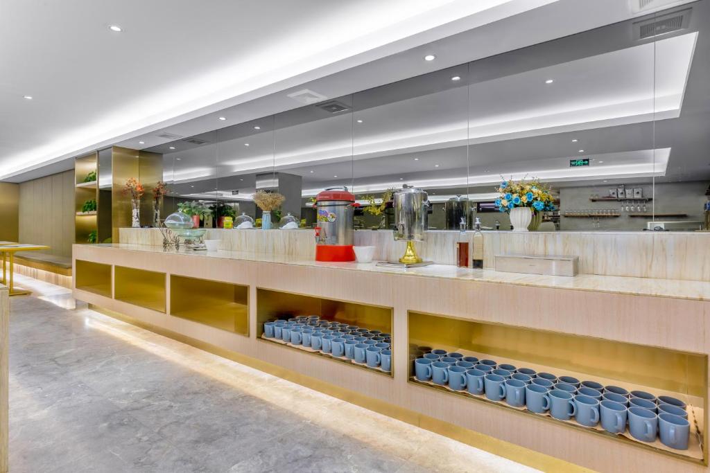 a restaurant with a counter with blue bottles at Tuke China Hotel -Wenzhou South Bus Terminal in Wenzhou