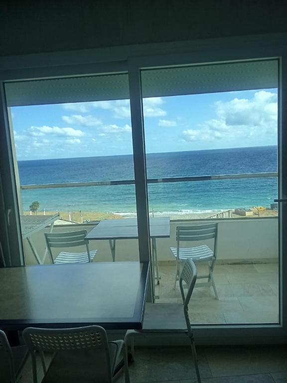 Camera con vista sull'oceano, tavolo e sedie. di AppartF3 vue panoramique sur mer Residence Vista Del Mar a Fnidek