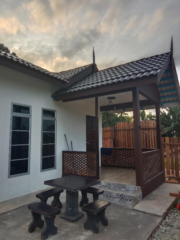 a picnic table and benches in front of a gazebo at Rumah Comel Temerloh Studio in Temerloh