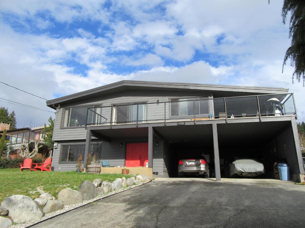 a house with a garage with a car in it at Sunshine Coast Suites in Sechelt