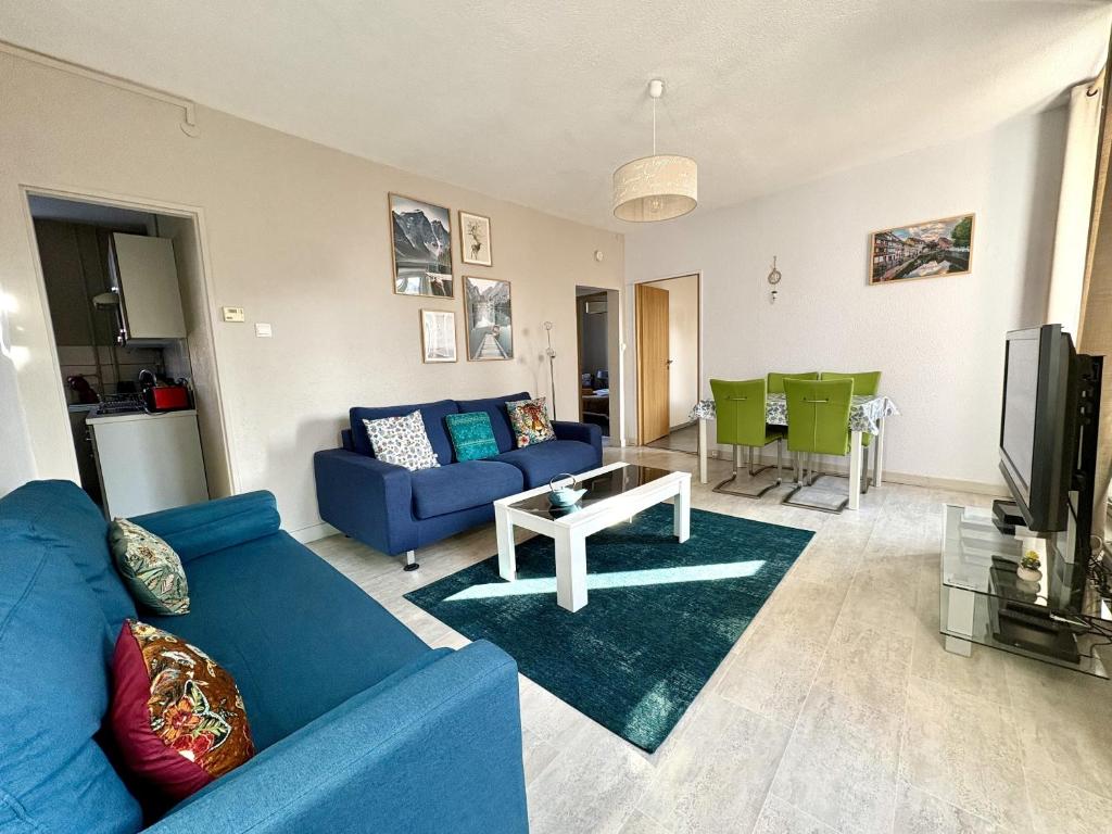 un salon avec un canapé bleu et une table dans l'établissement i-love-colmar - Les Remparts - Parking, à Colmar
