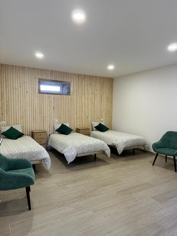 a room with three beds and green chairs at Forno House - Quarto peregrinos Caminho Santiago in Âncora