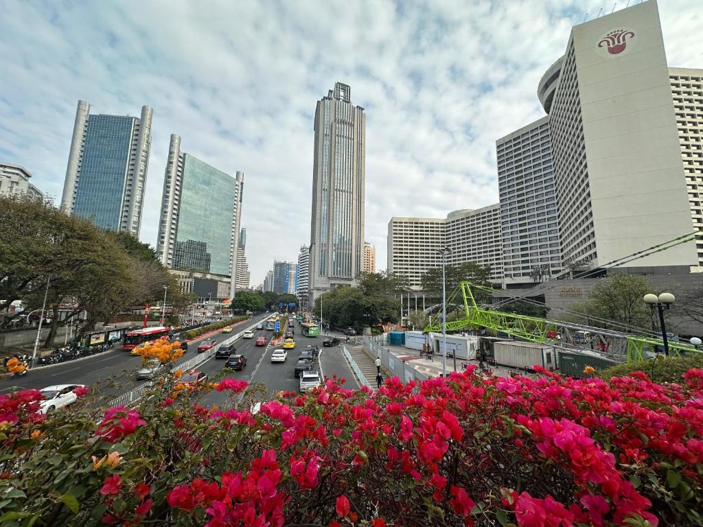 una trafficata strada cittadina con auto, fiori ed edifici di Guangzhou Youke Serviced Apartment1min to Line5 Taojin STN-Free shuttle bus during the Canton Fair a Canton