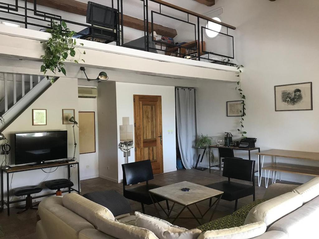 un salon avec un canapé, une télévision et une table dans l'établissement Villa dans la nature, à Gémenos