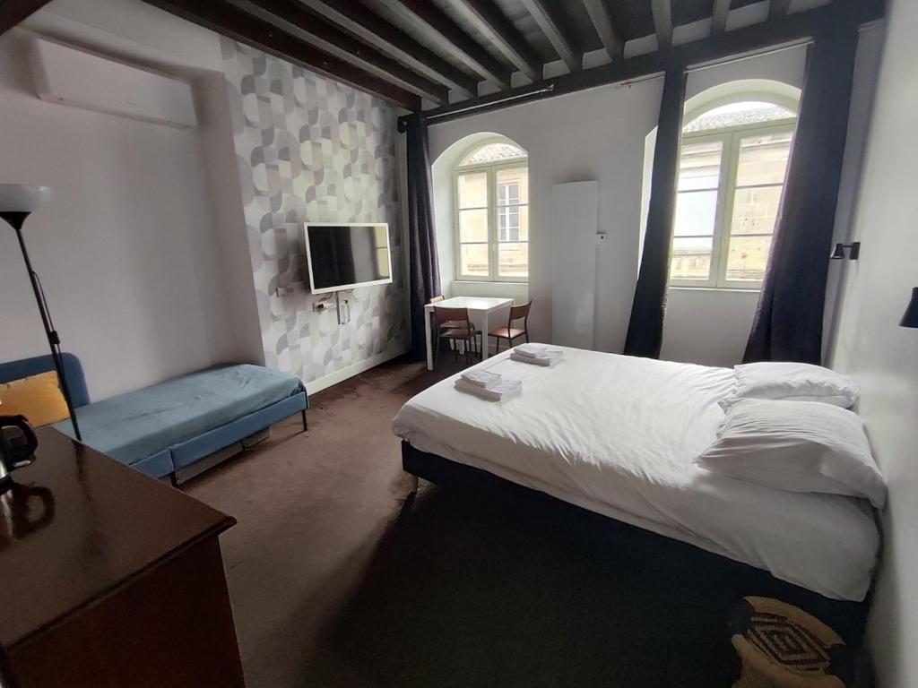 a bedroom with a large bed and a tv at Appartement 3 personnes quartier Chartrons avec climatisation in Bordeaux