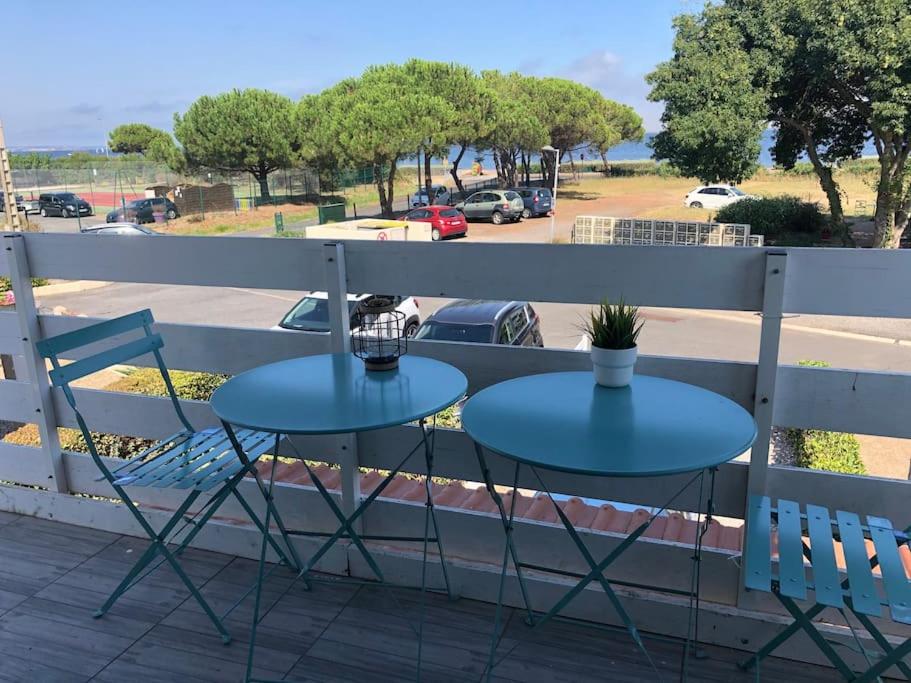 - deux tables sur un balcon avec vue sur un parking dans l'établissement Appartement T2 face a l etang sans vis a vis, à Marseillan
