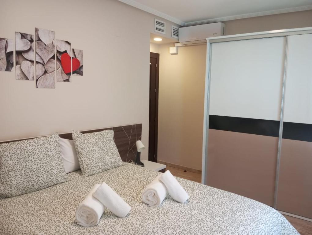 a bedroom with a large bed with white pillows at PLAZA AYUNTAMIENTO 3 HABITACIONES PONDoS in Linares