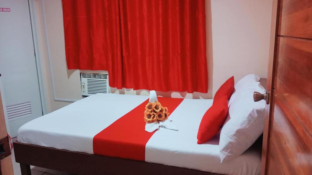 a bedroom with a bed with a red curtain at WJV Inn Bohol in Tagbilaran City