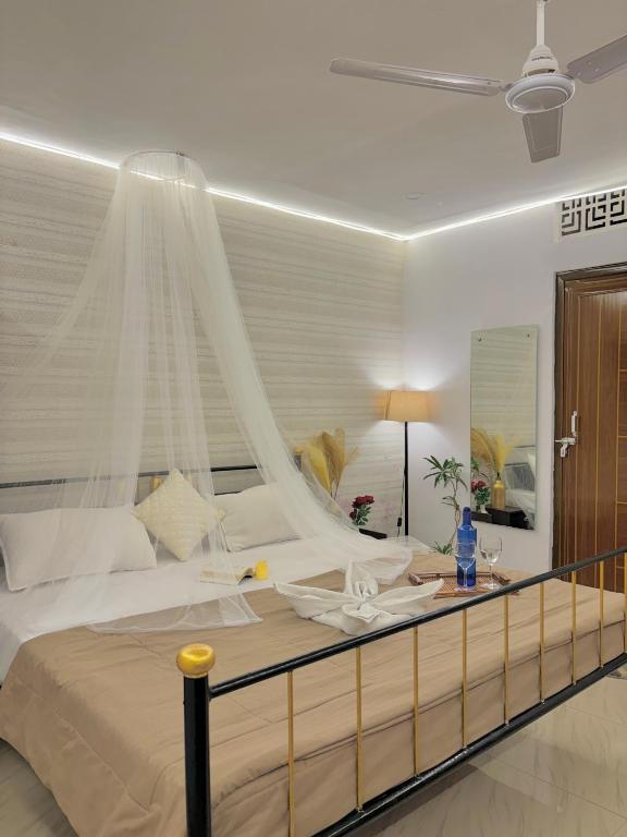 a bedroom with a large white bed with a canopy at The First Floor I Top Rated Boutique Homestay I Near Lekhraj Metro Lucknow in Lucknow
