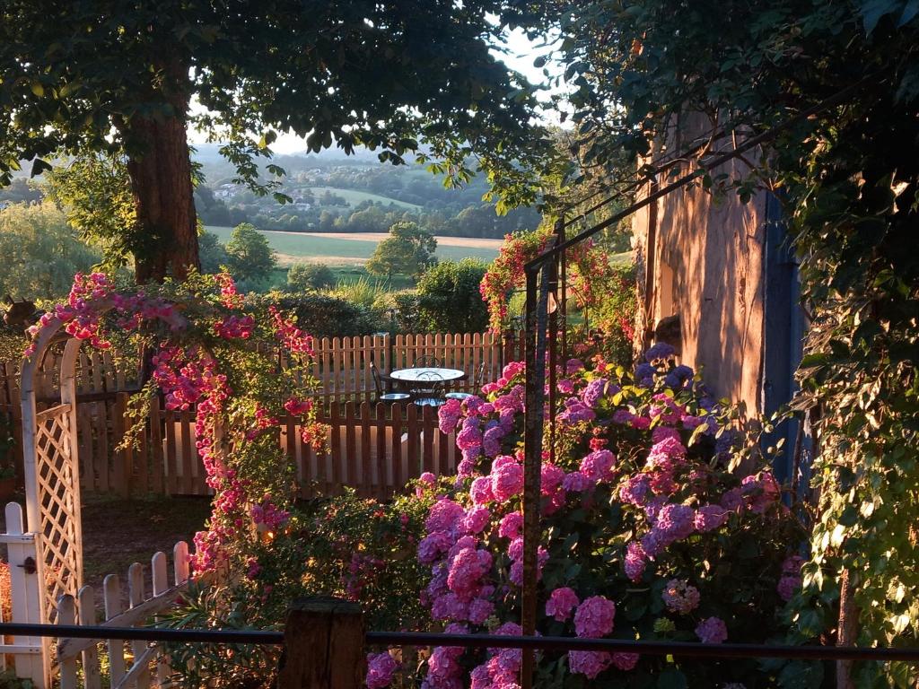 a garden with pink flowers and a fence at la maison d'Anna chambres d hôtes in Ganac