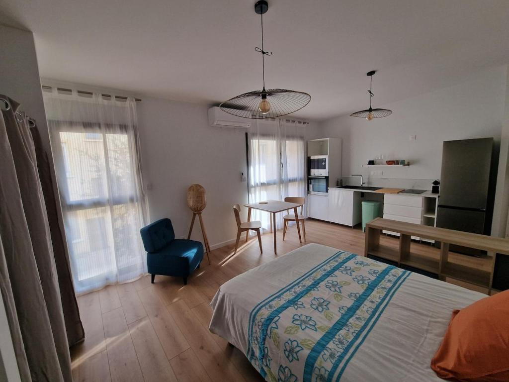 une chambre avec un lit et une table et une cuisine dans l'établissement Studio neuf climatisé wifi 27m2, à Oullins