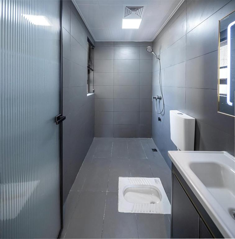 a bathroom with a toilet and a sink at Phoenix Tree Lodge in Fuli