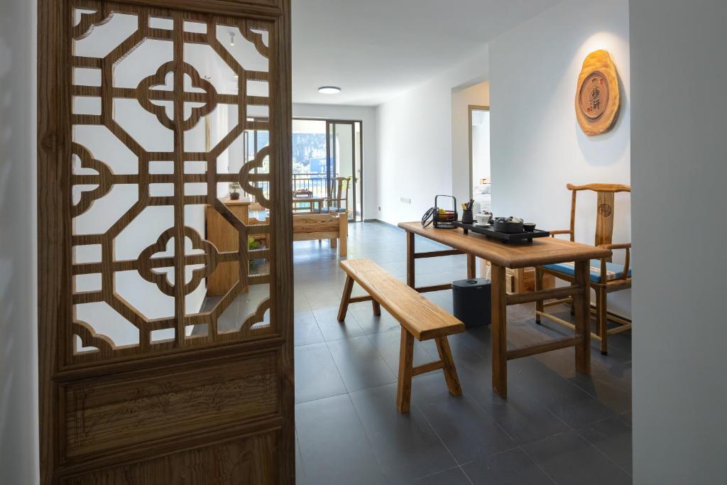 a room with a wooden door and a table and chairs at Phoenix Tree Lodge in Fuli