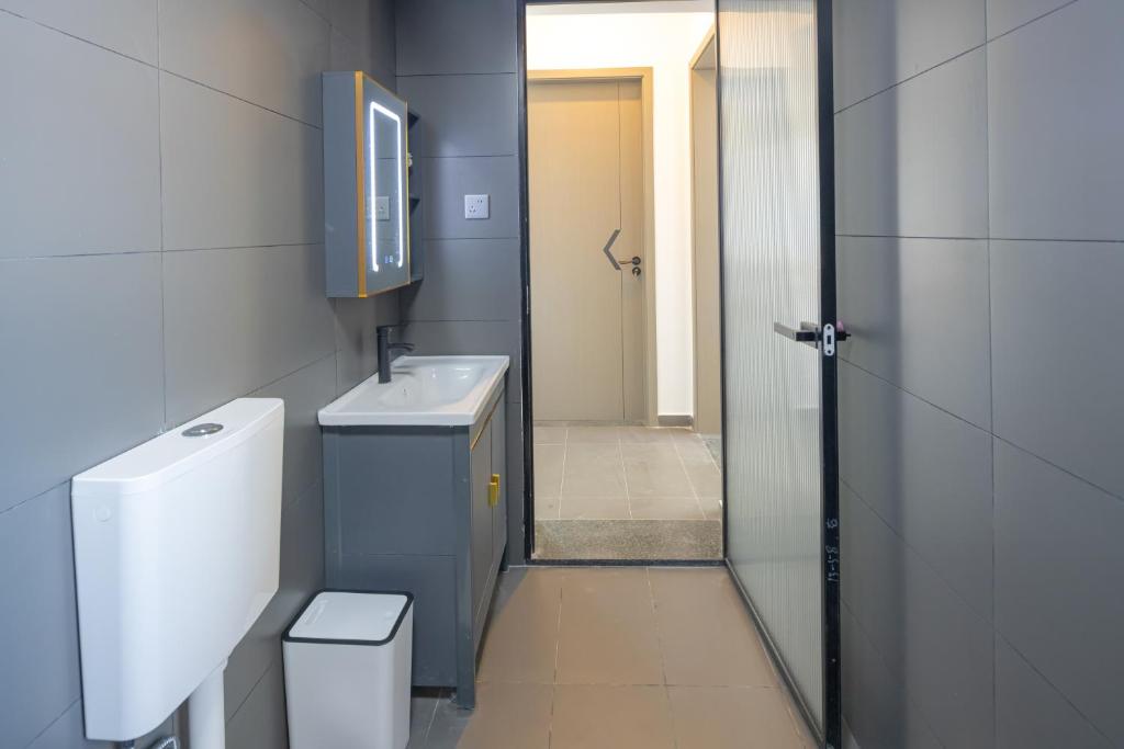a bathroom with a toilet and a sink and a mirror at Phoenix Tree Lodge in Fuli