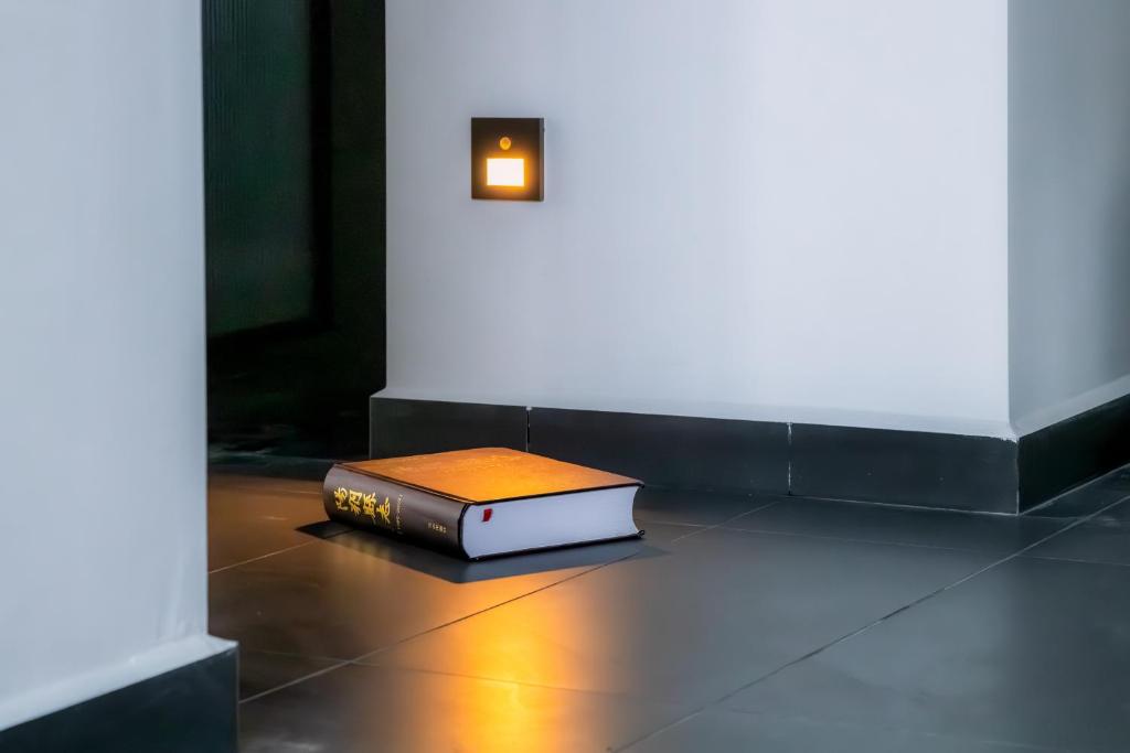 a book sitting on the floor next to a wall at Phoenix Tree Lodge in Fuli