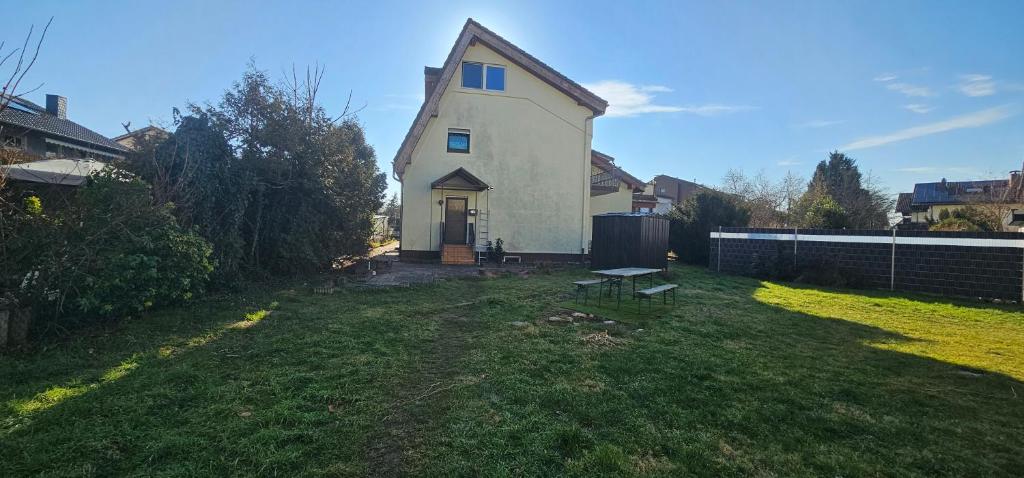 a small white house with a grass yard at Ruhige Gartenwohnung in Ketsch