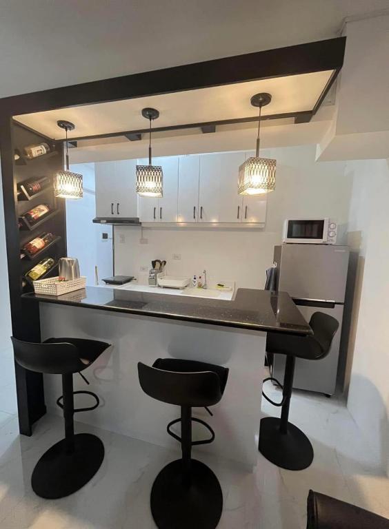 a kitchen with a counter and two bar stools at Mamitas Place, Royal Oceancrest Mactan in Lapu Lapu City