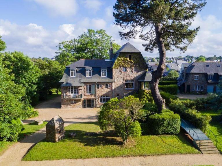 une grande maison en pierre avec un arbre dans la cour dans l'établissement Grande villa maritime à Perros-Guirec - Vue mer - Proche plage, à Perros-Guirec
