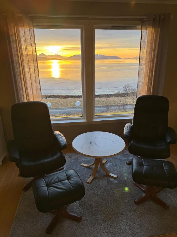 a room with two chairs and a table and a window at House in Vangsvik in Senja