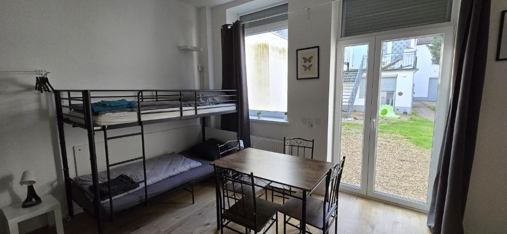 Zimmer mit einem Tisch und einem Etagenbett in der Unterkunft Monteurwohnung Ferienwohnung Krefeld Nähe Düsseldorf 2-4 Personen in Krefeld
