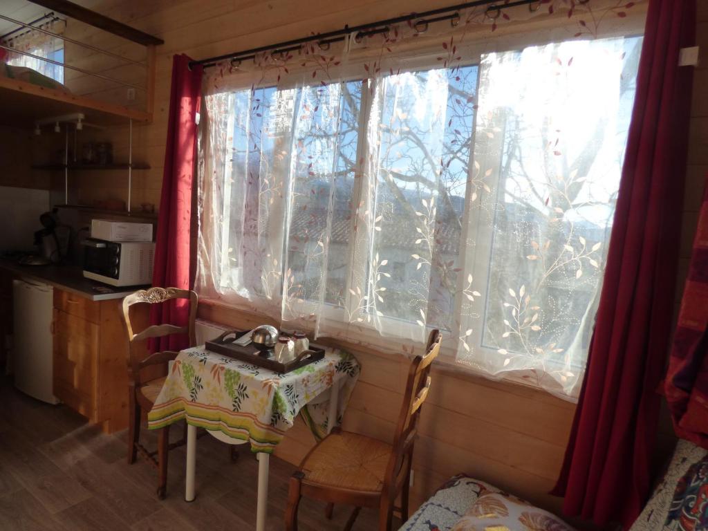 a small table and a window in a room at Tiny House lumineuse et ressourçant in Le Brusquet