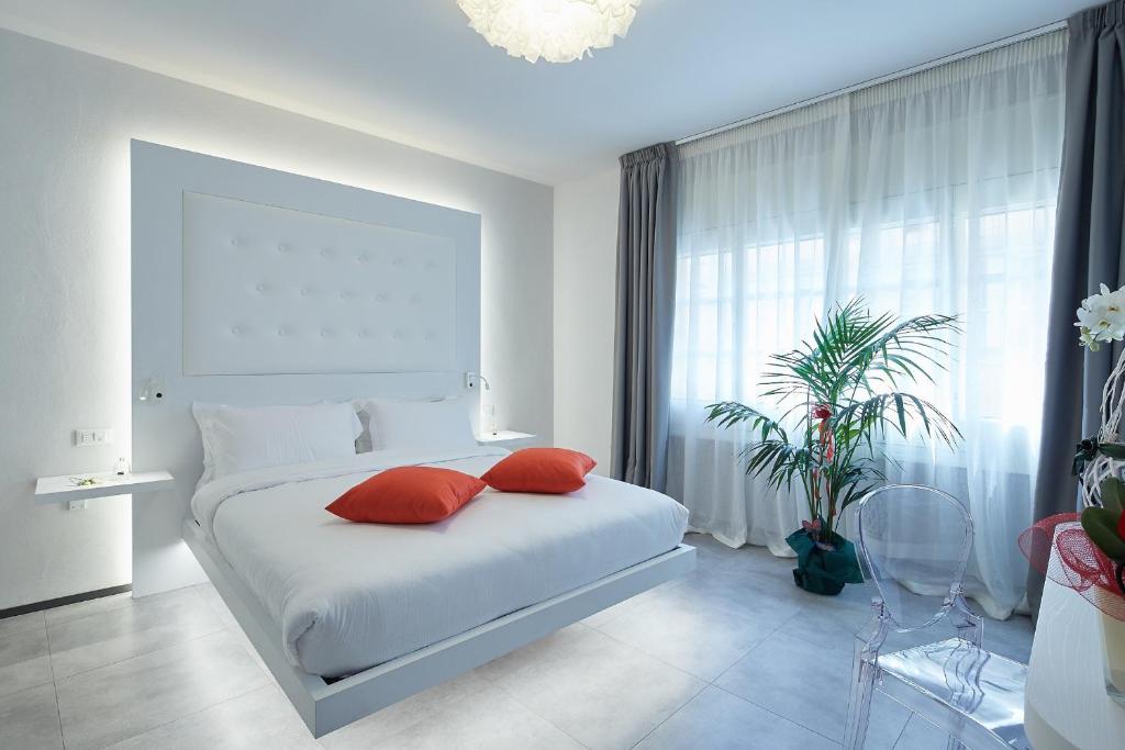 a bedroom with a white bed with two red pillows at Via Roma 25 Bed&Breakfast in Arezzo