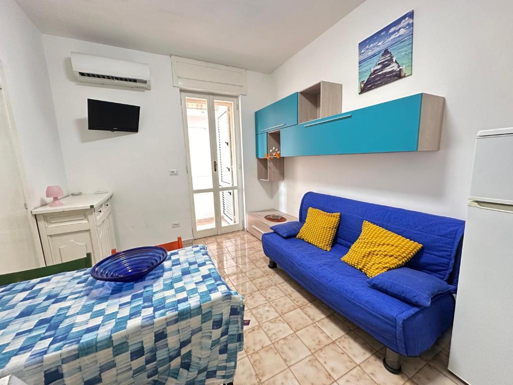 a living room with a blue couch and a bed at Baia Piccola in Baia Verde