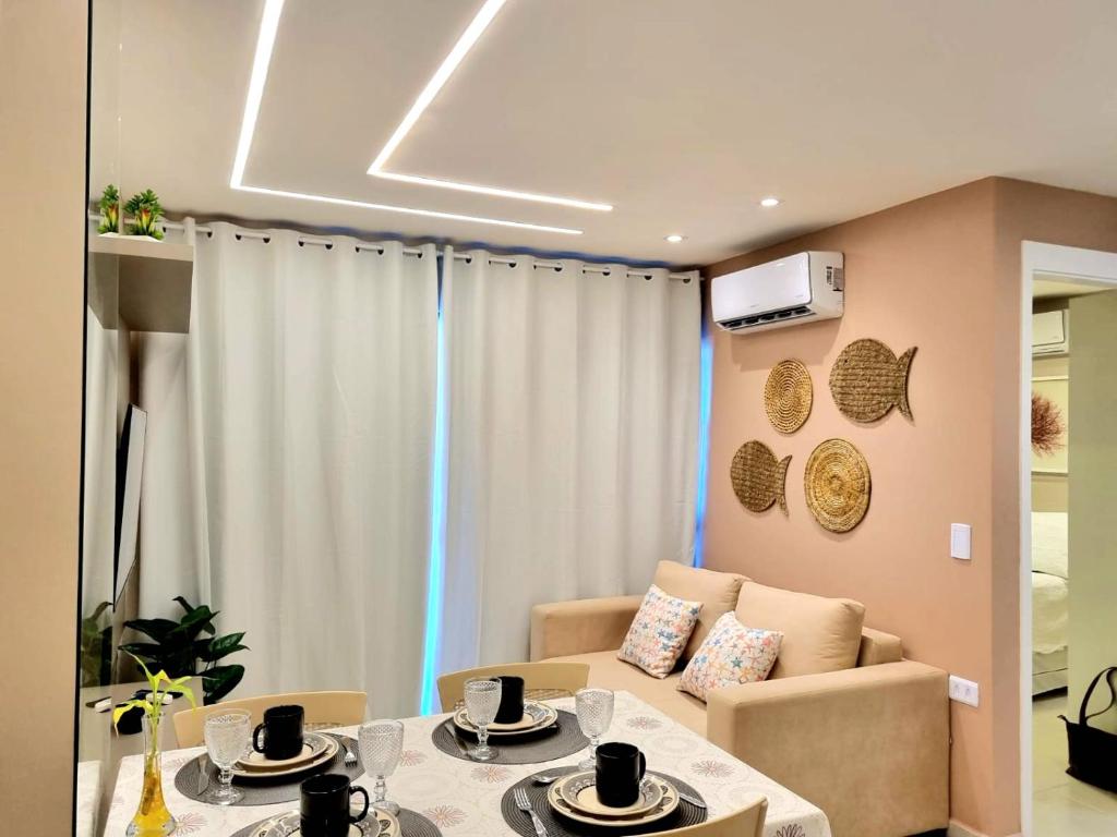 un salon avec une table et un canapé dans l'établissement Flat charmoso no Centro de Porto de Galinhas, à Porto de Galinhas